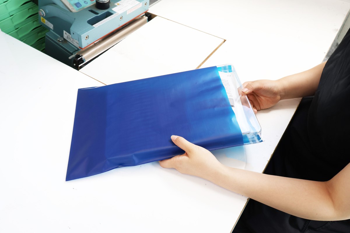 紺色のHDPE規格袋に商品を入れている作業の様子